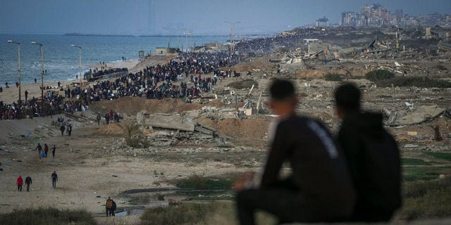 Δύο αγόρια παρακολουθούν το πλήθος των Παλαιστινίων που επιστρέφει στη βόρεια Γάζα, ανάμεσα σε κατεστραμμένα κτίρια, μετά την απόφαση του Ισραήλ να επιτρέψει σε χιλιάδες από αυτούς να επιστρέψουν για πρώτη φορά από τις πρώτες εβδομάδες του πολέμου τη Δευτέρα 27 Ιανουαρίου 2025