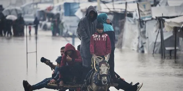 Παλαιστίνιοι διασχίζουν έναν πλημμυρισμένο δρόμο μετά από έντονη βροχόπτωση στη Χαν Γιούνις, στη νότια Λωρίδα της Γάζας, την Πέμπτη 11 Δεκεμβρίου 2025