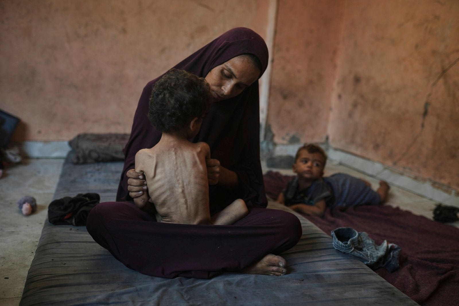 Η Ναΐμα Αμπού Φουλ κρατά στην αγκαλιά της το υποσιτισμένο δίχρονο παιδί της, τον Γιαζάν, στο σπίτι τους στον προσφυγικό καταυλισμό Σάτι, στην πόλη της Γάζας, την Τετάρτη 23 Ιουλίου 2025