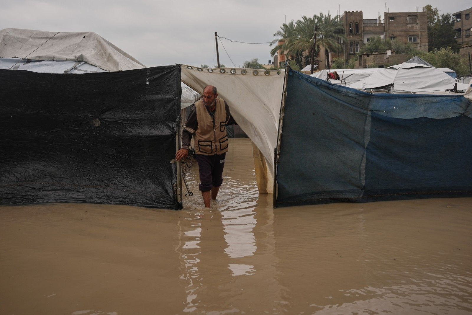 Ο Χαλίλ Αγιές, 65 ετών, στέκεται στην είσοδο της πλημμυρισμένης σκηνής του σε προσωρινό καταυλισμό για εκτοπισμένους Παλαιστίνιους μετά από έντονες βροχοπτώσεις στο Ντέιρ αλ-Μπάλαχ, στην κεντρική Λωρίδα της Γάζας, την Παρασκευή 12 Δεκεμβρίου 2025