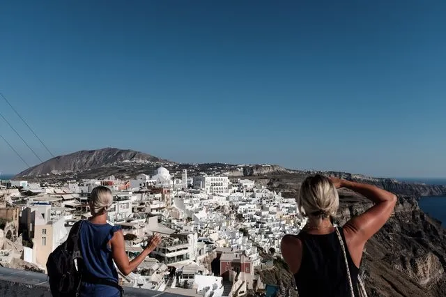 Τουρίστες βλέπουν τα Φηρά από ψηλά. Κάθε χρόνο η πόλη μεγαλώνει…