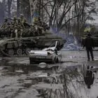 Ουκρανικό τανκ περνά δίπλα από ένα κατεστραμμένο αμάξι έξω από το Κίεβο, όπου πραγματοποιήθηκαν μάχες μεταξύ Ρώσων και Ουκρανών