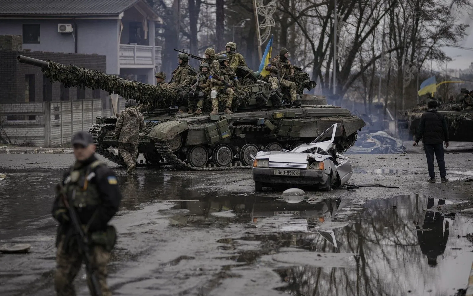 Ουκρανικό τανκ περνά δίπλα από ένα κατεστραμμένο αμάξι έξω από το Κίεβο, όπου πραγματοποιήθηκαν μάχες μεταξύ Ρώσων και Ουκρανών