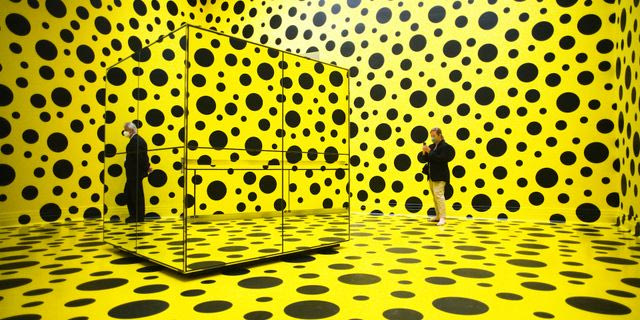 People walk through the art work 'THE SPIRITS OF THE PUMPKINS DESCENDED INTO THE HEAVENS' by Yayoi Kusama, during the press preview of a retrospective exhibition of the Japanese artist at the Martin Gropius Bau museum in Berlin, Germany, Thursday, April 22, 2021. The exhibition will run from April 23 to August 15, 2021.
