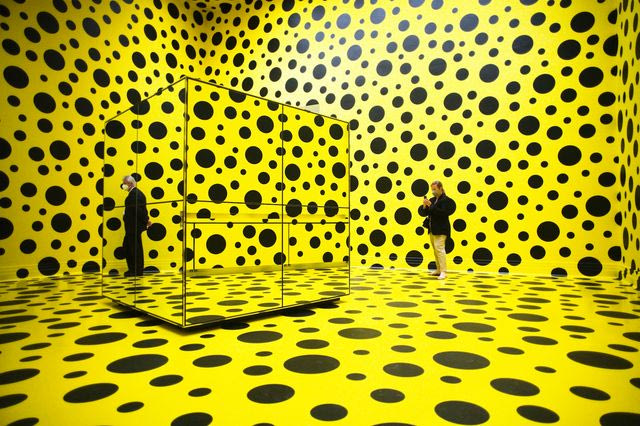 People walk through the art work 'THE SPIRITS OF THE PUMPKINS DESCENDED INTO THE HEAVENS' by Yayoi Kusama, during the press preview of a retrospective exhibition of the Japanese artist at the Martin Gropius Bau museum in Berlin, Germany, Thursday, April 22, 2021. The exhibition will run from April 23 to August 15, 2021.