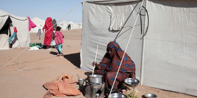Μια Σουδανή γυναίκα εκτοπισμένη από το Ελ-Φάσερ μαγειρεύει έξω από τη σκηνή της στο νεοϊδρυθέν στρατόπεδο Ελ-Αφάντ, στην περιοχή Αλ Ντάμπα, στη Βόρεια Πολιτεία του Σουδάν.