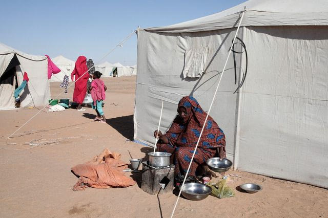 Μια Σουδανή γυναίκα εκτοπισμένη από το Ελ-Φάσερ μαγειρεύει έξω από τη σκηνή της στο νεοϊδρυθέν στρατόπεδο Ελ-Αφάντ, στην περιοχή Αλ Ντάμπα, στη Βόρεια Πολιτεία του Σουδάν.