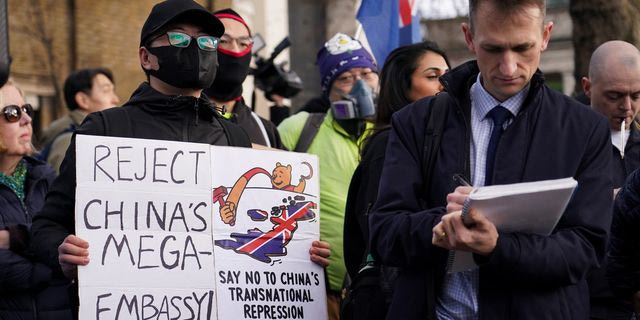 Demonstrators hold placards and flags as they attend a protest against the opening of the new Chinese embassy, in London, Saturday, Jan. 17, 2026.