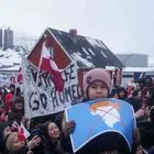 Ένα αγόρι κρατά μια εικόνα με διαγραμμένο χάρτη της Γροιλανδίας που πάνω του έχει μια περούκα που συμβολίζει τον Τραμπ, στη διαδήλωση μπροστά από το αμερικανικό προξενείο στο Νουούκ της Γροιλανδίας