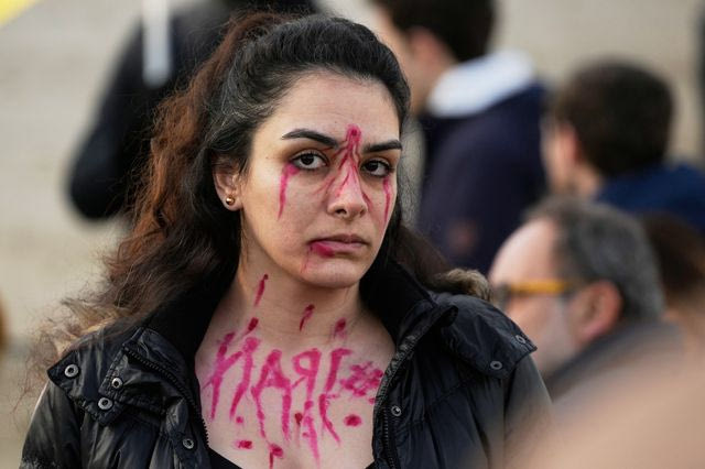 Διαδηλώτρια με βαφή στο πρόσωπο για να αναπαραστήσει τις σφαίρες