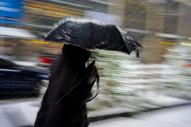 Γυναίκα κρατάει ομπρέλα κατά τη διάρκεια καταιγίδας