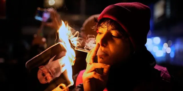 Διαδηλωτής καίει με τσιγάρο φωτογραφία του Χαμενεΐ