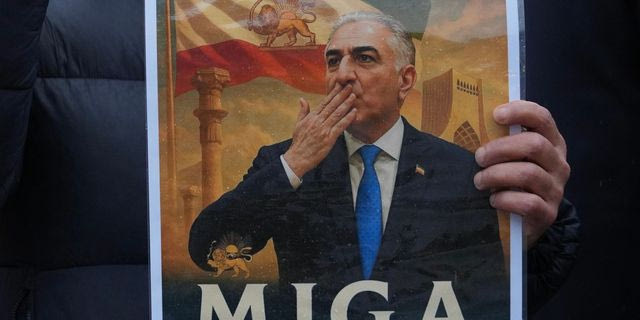 Διαδηλωτής κρατά στα χέρι του αφίσα του Ρεζά Παχλαβί