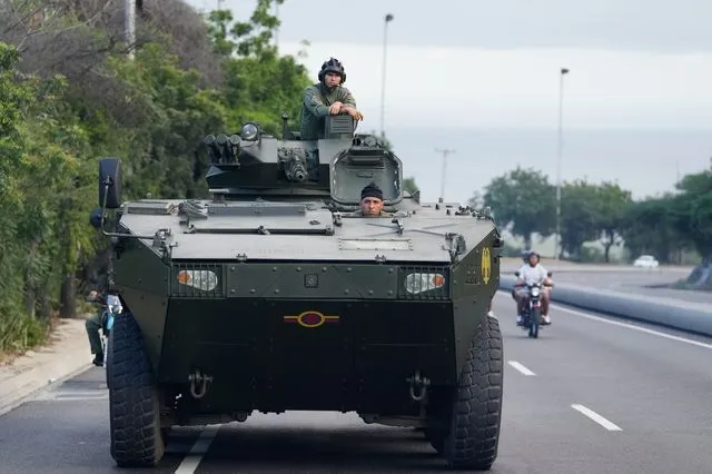 Ένας στρατιώτης στέκεται πάνω σε ένα θωρακισμένο όχημα στον αυτοκινητόδρομο που οδηγεί από το διεθνές αεροδρόμιο προς το Καράκας της Βενεζουέλας,