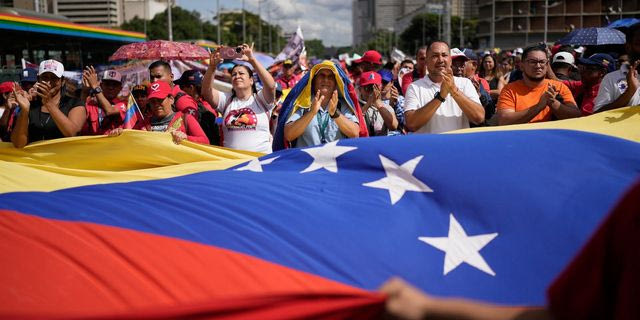 Διαδηλωτές κρατούν σημαία της Βενεζουέλας