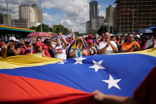 Διαδηλωτές κρατούν σημαία της Βενεζουέλας