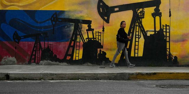 Ένας ντόπιος περπατάει δίπλα σε μια τοιχογραφία με αντλίες πετρελαίου και πηγάδια στο Καράκας της Βενεζουέλας, Τρίτη, 6 Ιανουαρίου 2026.