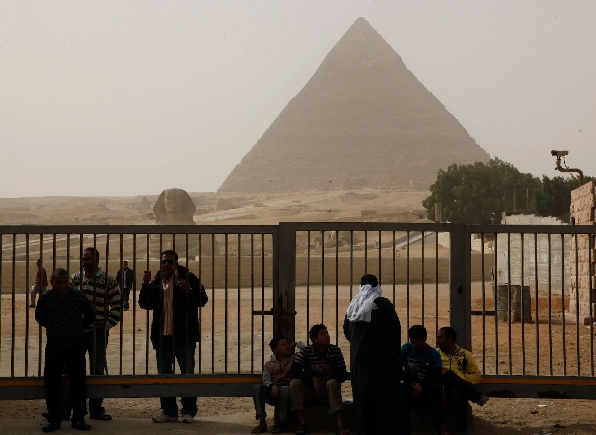 Egyptian tourist guides and security sit near the Pyramids, in Giza, Egypt, Saturday, Jan. 29, 2011. The Pyramids are closed to tourists.