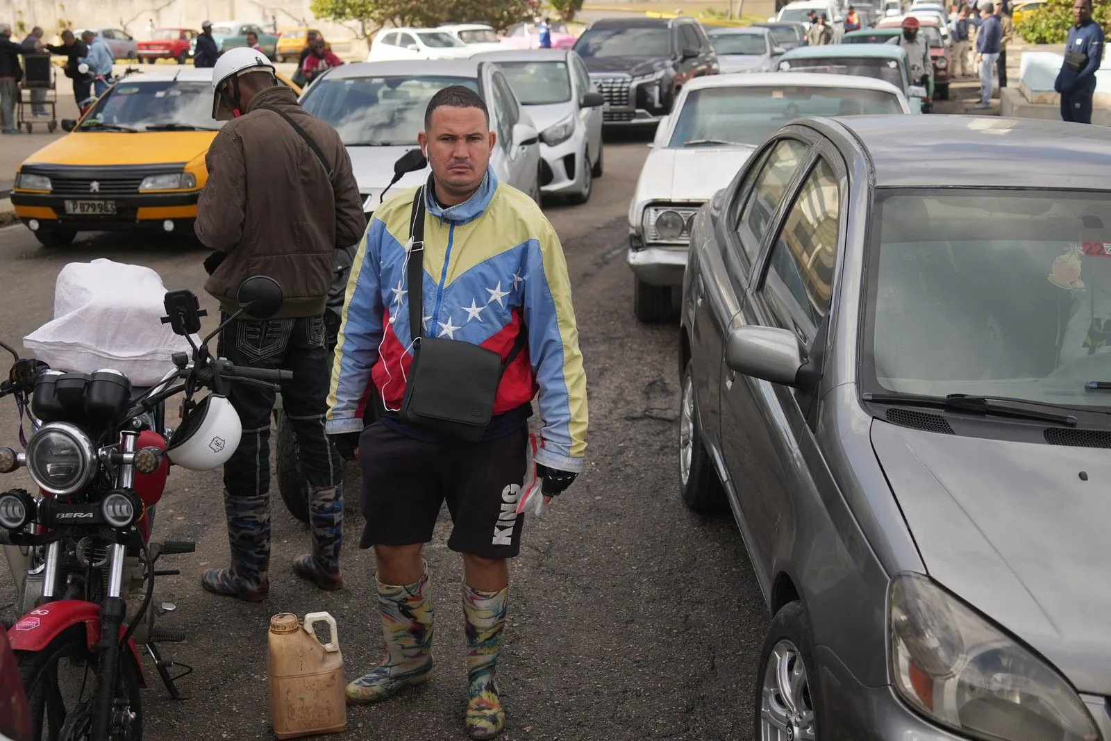 Κουβανός με ρούχα στα χρώματα της Βενεζουέλας περιμένει στην ουρά για πετρέλαιο