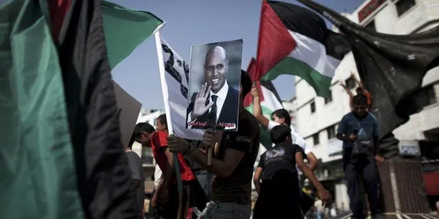 Διαδηλωτής κρατάει πλακάτ με τον γιο του Καντάφι