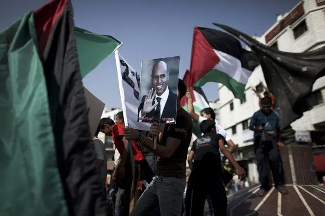 Διαδηλωτής κρατάει πλακάτ με τον γιο του Καντάφι