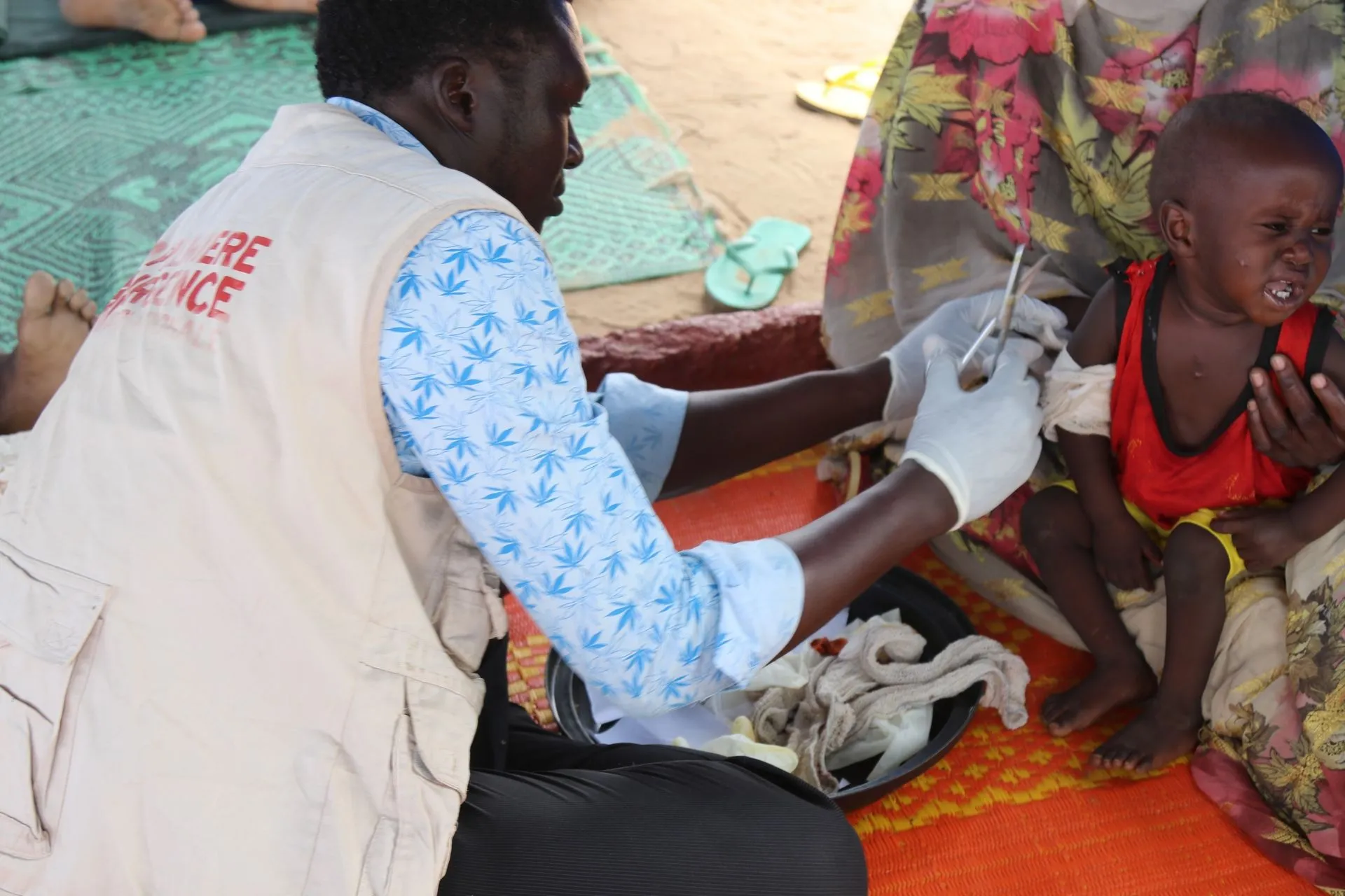 Προσωπικό ΜΚΟ δίνει τις πρώτες βοήθειες σε μια οικογένεια απο το Σουδαν στο πρόχειρο νοσοκομείο του Αντρέ