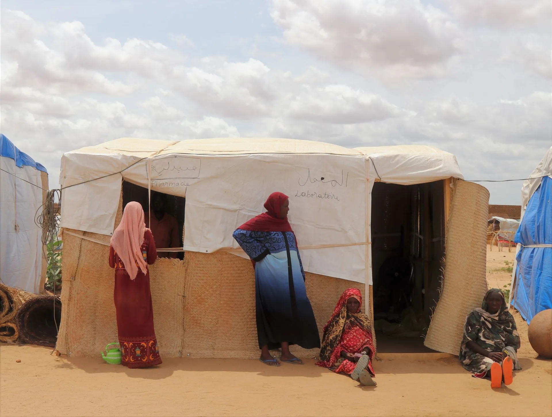 Σουδανές γυναίκες περιμένουν έξω από την πρόχειρη κλινική στον καταυλισμό του Αντρέ, στο ανατολικό Τσαντ.