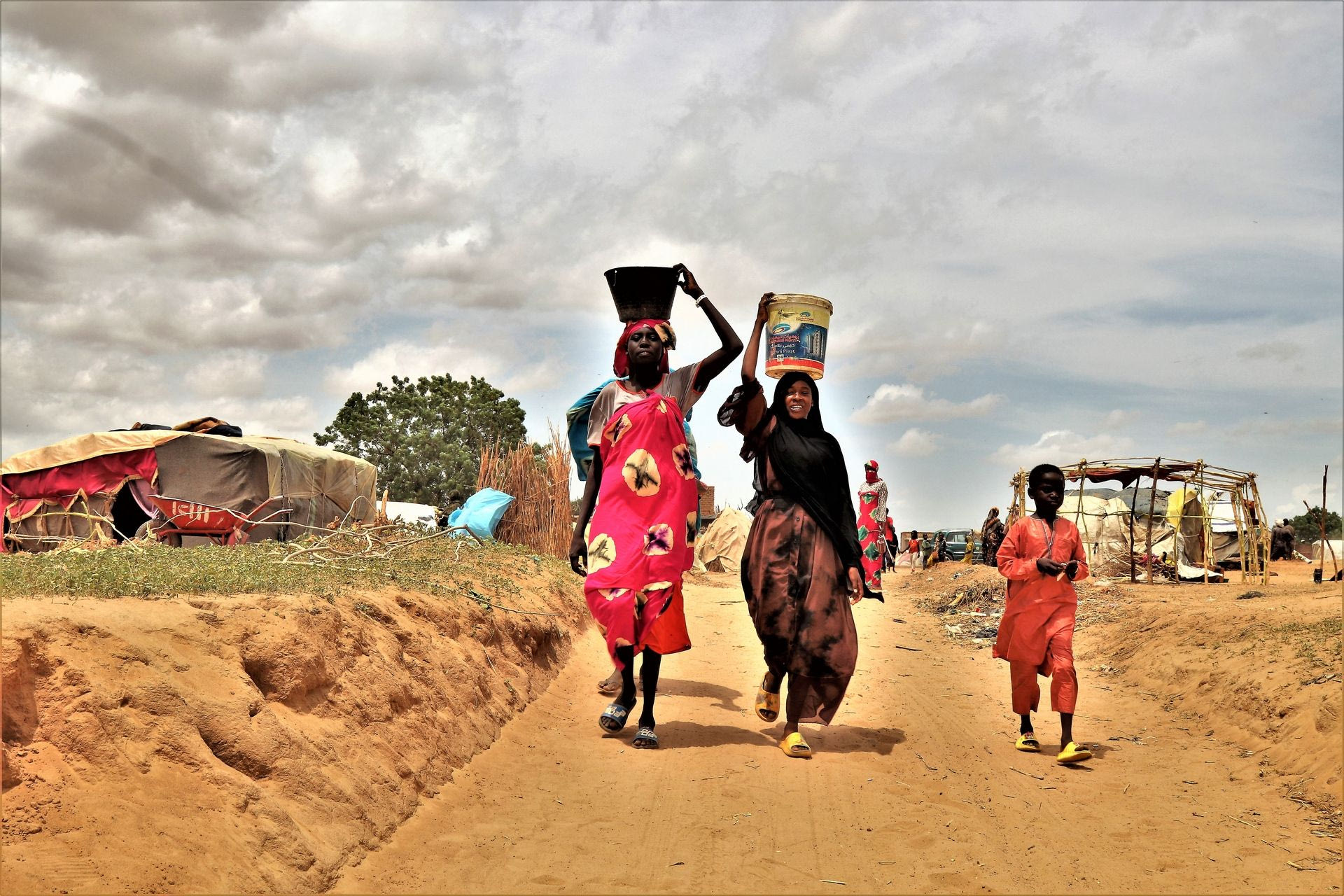 Σουδανές μεταφέρουν νερό στον πρόχειρο καταυλισμό προσφύγων στην πόλη Αντρέ. Η πόλη φιλοξενεί πάνω απο 200 000 πρόσφυγες, κυρίως Μασαλιτ απο το δυτικό Νταρφουρ.