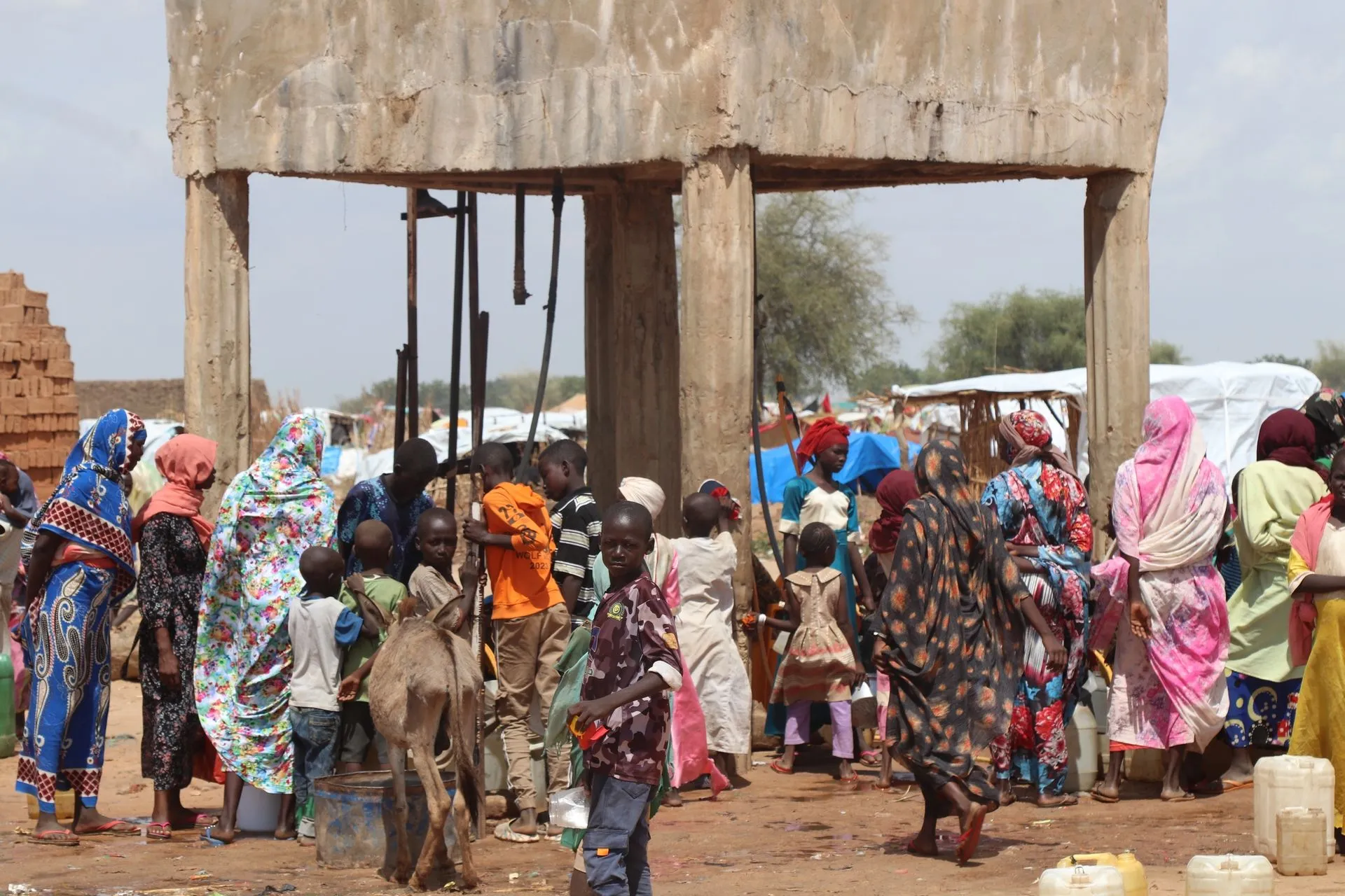 Στον καταυλισμό Farchana, κάθε μέρα Σουδανοί πρόσφυγες περιμένουν ώρες για ένα δοχείο νερό. Το πόσιμο νερό στην περιοχή είναι περιορισμένο, γεγονός που δημιουργεί εντάσεις με την ντόπια κοινότητα
