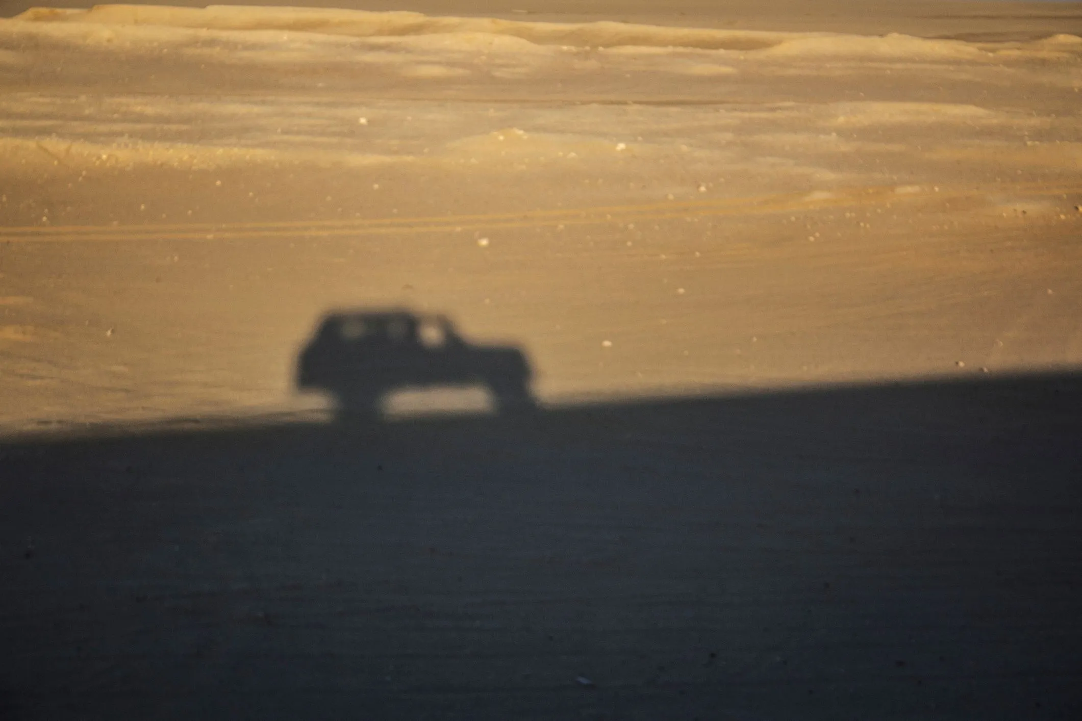 Silhouette shadow of a safari car on the sand at Wadi Al-Hitan, Whale Valley, Faiyum in the Western Desert of Egypt