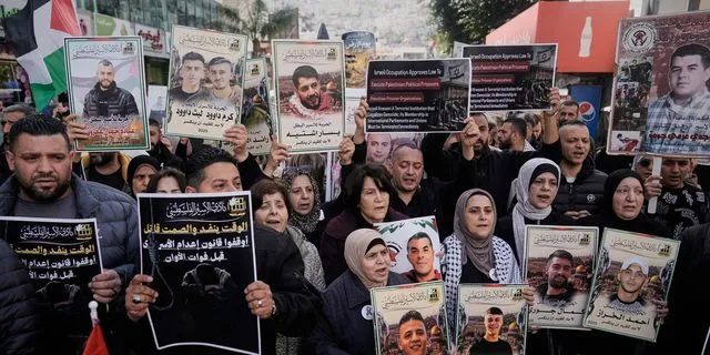 Παλαιστίνιοι διαδηλώνουν στην κατεχόμενη Δυτική Όχθη κρατώντας φωτογραφίες κρατουμένων στις ισραηλινές φυλακές