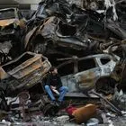 Ένας νεαρός κάθεται δίπλα σε απανθρακωμένα αυτοκίνητα και συντρίμμια στο Ιράν