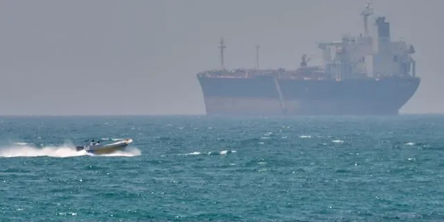 Ένα σκάφος πλέει δίπλα από ένα δεξαμενόπλοιο αγκυροβολημένο στα στενά του Ορμούζ - Σάββατο, 18 Απριλίου 2026