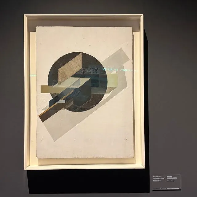 Γκούσταβ Κλούτσις [Ρουγιένα (Ρωσική Αυτοκρατορία, σημ. Λετονία) 1895 – εκτελέστηκε Μόσχα (ΕΣΣΔ, σημ. Ρωσία) 1938] Δυναμική πόλη, 1919 Λάδι, ξυρόδεμα και άμμος σε ξύλο, 87 × 63,5 εκ. MOMUS-Μουσείο Μοντέρνας Τέχνης-Συλλογή Κωστάκη Αρ. έργου 94.78