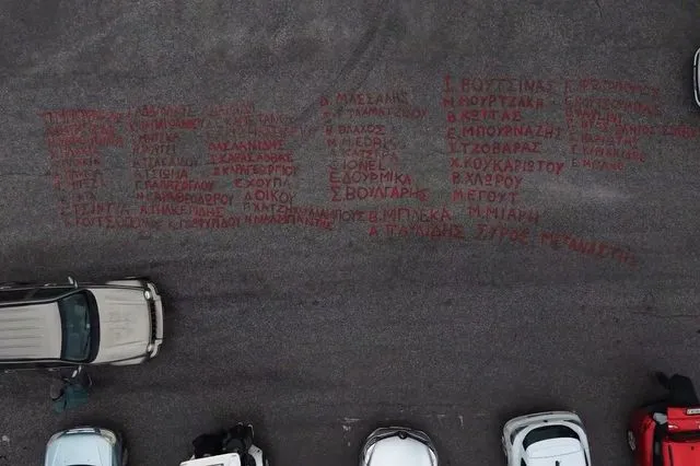 Δίκη για τα Τέμπη: Τα ονόματα των 57 θυμάτων γραμμένα με μπογιά έξω από το συνεδριακό κέντρο