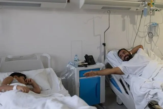 Ο Σύριος πρόσφυγας Αμπντουλαζίζ Αλνταρβίς, 32 ετών, έχει φτάσει στο Ωνάσειο Νοσοκομείο και εντώνει το χέρι του προς τον γιο του Γιαχία Αλνταρβίς, 10 ετών, λίγο πριν από τη μεταμόσχευση νεφρού στην οποία ο Αμπντουλαζίζ είναι ο δότης.