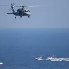 Αμερικανικό ελικόπτερο MH-60 Seahawk πετά πάνω από περιπολικά σκάφη των Φρουρών της Ισλαμικής Επανάστασης του Ιράν, στο Στενό του Ορμούζ (φωτογραφία αρχείου)