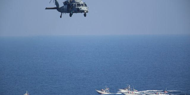 Αμερικανικό ελικόπτερο MH-60 Seahawk πετά πάνω από περιπολικά σκάφη των Φρουρών της Ισλαμικής Επανάστασης του Ιράν, στο Στενό του Ορμούζ (φωτογραφία αρχείου)