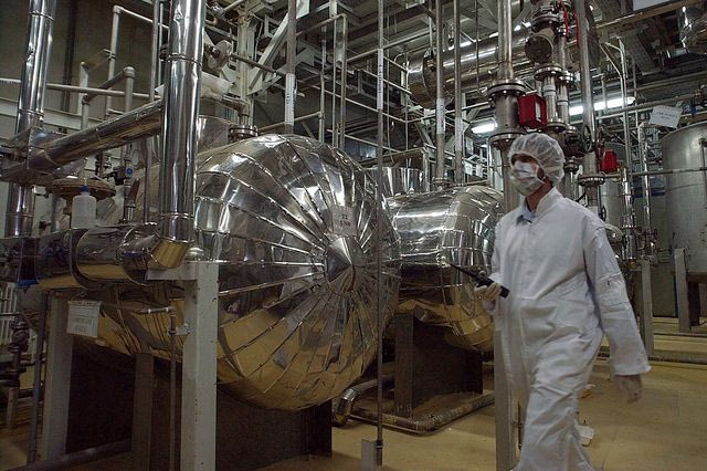 Ένας Ιρανός αξιωματούχος ασφαλείας με προστατευτική ενδυμασία περπατά μέσα από μέρος της Εγκατάστασης Μετατροπής Ουρανίου λίγο έξω από την πόλη Ισφαχάν
