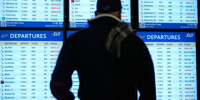 Ταξιδιώτης κοιτάζει στον πίνακα αναχωρήσεων τις πολλαπλές ακυρώσεις πτήσεων