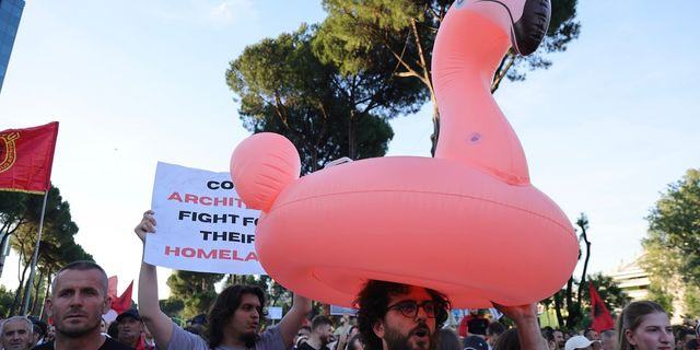 Ένας διαδηλωτής κρατάει φουσκωτό φλαμίνγκο κατά τη διάρκεια συγκέντρωσης στα Τίρανα