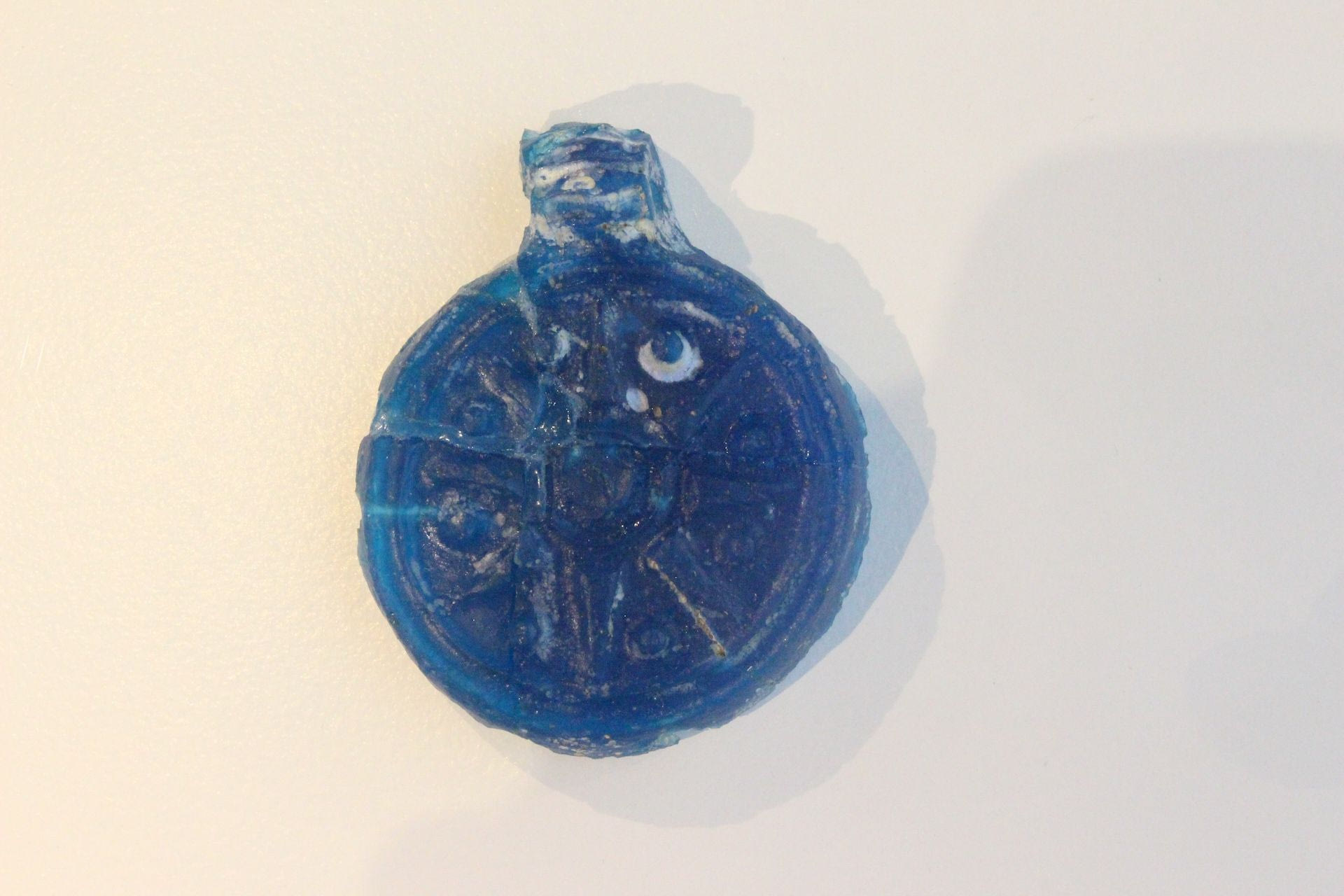 ΜΧ 9573. Φυλακτό από ημιδιαφανές μπλέ γυαλί, εισηγμένο από περιοχή του σημερινού Ιράκ.
