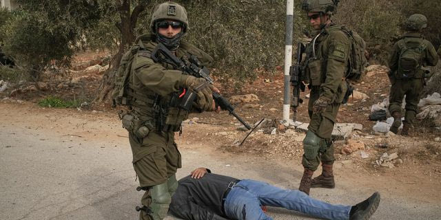 Ισραηλινοί στρατιώτες στέκονται πάνω από έναν Παλαιστίνιο τον οποίο πυροβόλησαν στον μηρό, στη Δυτική Όχθη